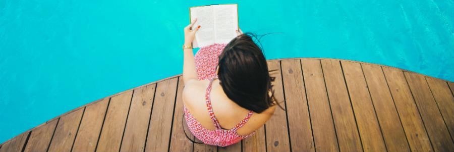 Kvinde læser ved pool